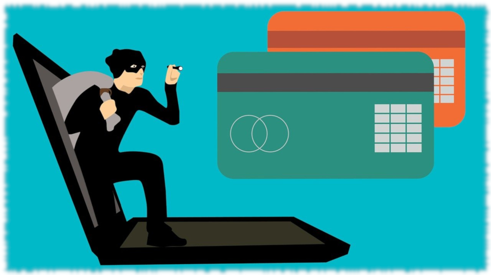 Immagine raffigurante un computer, delle carte di credito e un uomo incappucciato in tipico atteggiamento del truffatore informatico